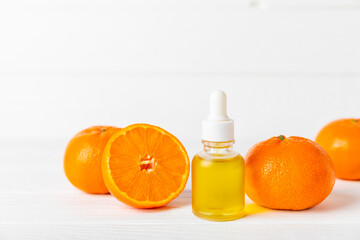 Tangerine essential oil on a wooden table. Bottles of citrus essential oil and sliced ​​fruits....