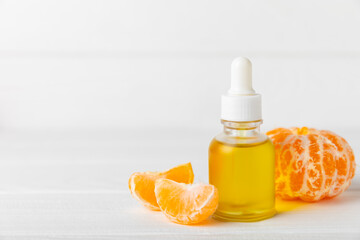 Tangerine essential oil on a wooden table. Bottles of citrus essential oil and sliced ​​fruits....