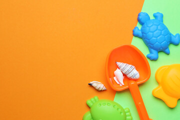 Children's beach toys and seashells on color background, flat lay. Space for text