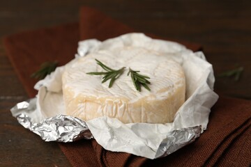 Dairy product. Fresh camembert and rosemary on wooden table, closeup