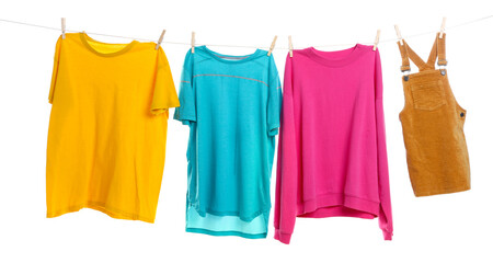 Different clothes drying while hanging on clothesline against white background