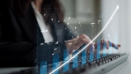 A professional woman engages with her laptop, analyzing financial data displayed through digital graphs and indicators, emphasizing growth and strategic planning in business. Copula