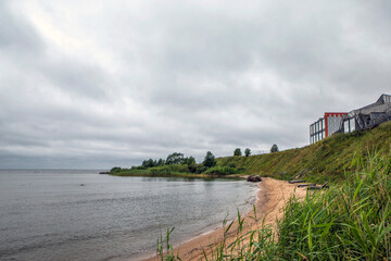 A deserted beach and the shore of Lake Peipus with cottages and glamping sites. Park-hotel "Peski." Zapolye village, Gdovsky district, Pskov region, Russia