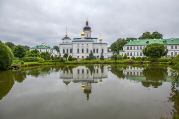 Monastery grounds with a pond and a view of the Cathedral of the Three Holy Hierarchs. Spaso-Eleazarovsky Convent. Elizarovo village, Pskov Oblast, Russia