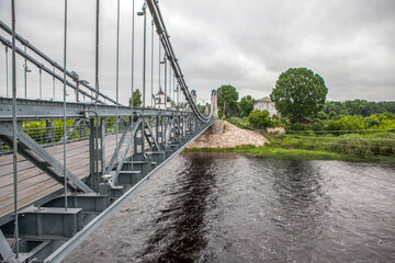 Chain Bridge over the Velikaya River and the Church of St. Nicholas the Wonderworker (Nikolskaya). Ostrov, Pskov Oblast, Russia