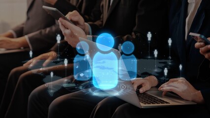 Business professionals engage with technology while discussing ideas and strategies, highlighting the importance of digital communication in today corporate environment. Raster