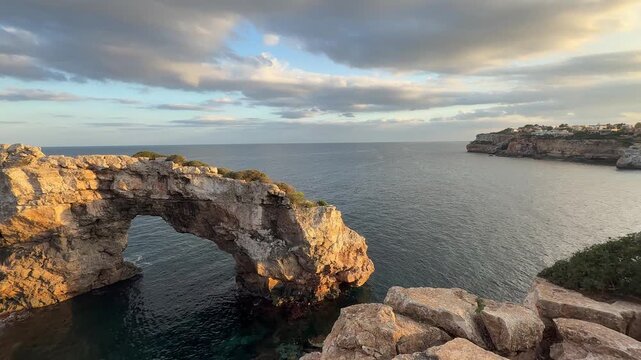 Es Pontas rock on Mallorca, Spain. Natural stone bridge between Cala Santanyi and Cala Llombards during the sunset panoramic view