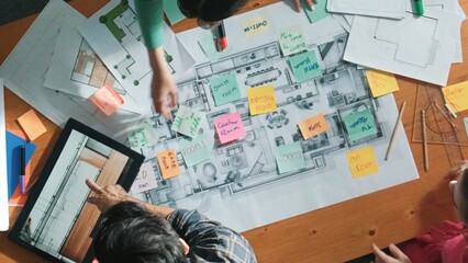 Top view of engineer working together to design building construction while standing at meeting table with blueprint and notes. Top view of interior designer choosing color from palettes. Symposium.