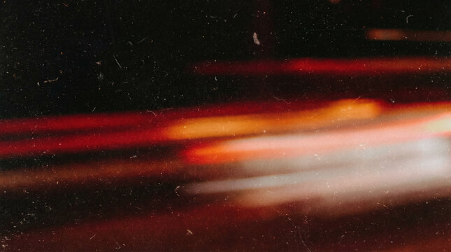 Fiery light leak overlay with orange red film burn streaks and dust texture, abstract cinematic flare background with retro grunge overlay effect, vintage analogue glow with soft blur and grain noise