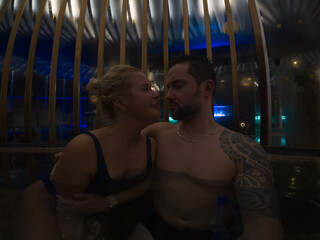 Atmospheric portrait of couple in hot Japanese spa pool with natural steam mist and moody dim lighting creating soft focus © Dmitri