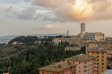 View of Perugia, Italy, with residential buildings in the foreground and historical structures, including a cathedral, in the background.