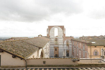The incomplete facade of the planned 'Duomo Nuovo' (Facciatone) in Siena, Italy, showing its unfinished structure and brickwork.