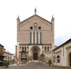 Facade of Chiesa di San Fermo Maggiore in Verona, Italy - Gothic-Romanesque striped facade with pinnacles, lancet windows and central portal.