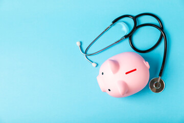 Medical costs, financial concept, health insurance. Stethoscope over dollar bills. Money and piggy bank. Medical care. Health care financial checkup or saving for medical insurance costs concept.