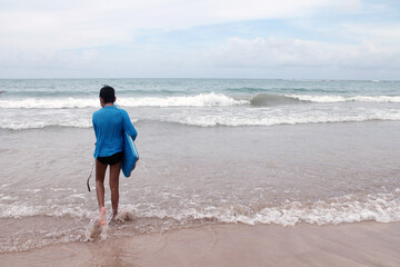 Child with a Kids Surfboard Heading into the Sea in Porto de Galinhas, Brazil
