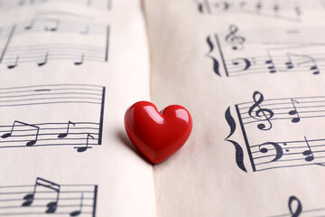 Heart figure on paper sheet with music notes, closeup