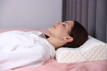 Obraz premium Young woman sleeping on bed with orthopedic pillow at home. Healthy posture