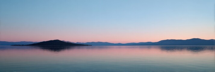 Obraz premium Serene lake at sunrise with calm waters and mountain silhouette