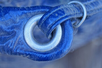 one white metal latch with a ring on a blue leather bag 