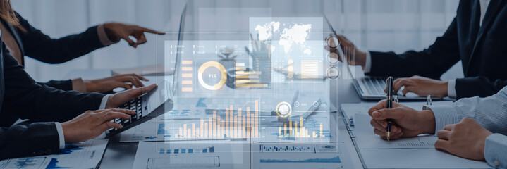 Business professionals engage in a collaborative meeting, analyzing data trends through a digital interface in a modern office, highlighting teamwork and technology integration. Scalp