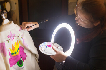 Vibrant hoodie art by artist, Skilled artist designs lively botanical hoodie imagery, Talented woman crafts energetic illustrations with natureinspired themes