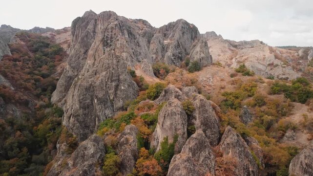 jagged rock ridge cuts through landscape, dramatic rocky skyline with layered summits and rough textures, drone angle emphasizes rugged geology and route options for climbers and trail crews mapping