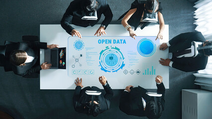 A dynamic business meeting showcasing innovative virtual reality technology used for open data analysis and interactive discussions among professionals in a modern office. Trope