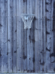 Basket ball hoop hanging off the side of alpine barn