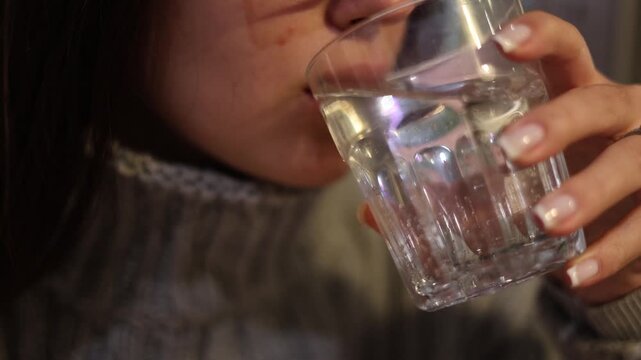Young woman drinking clean water from glass feeling thirst refreshment and hydration calm lifestyle moment at home natural light healthy daily habit wellness concept