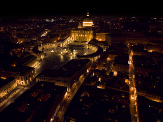 Obraz premium Vatican City and Saint Peter’s Square (Obelisco Vaticano di Piazza San Pietro) and Saint Peter’s Basilica (Basilica di San Pietro) drone view at night, Rome, Italy.