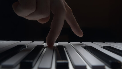 Playing a keyboard instrument. Close-up of a hand.