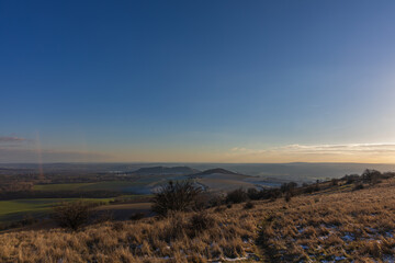 Winter Palava steppe at sunset. View of the rolling landscape of South Moravia with remnants of snow under a clear sky in Czechia