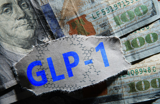 GLP-1 news headline and semaglutide molecule structure on assorted one hundred dollar bills
