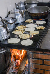 Obraz premium Traditional Costa Rican cuisine of tortillas cooking on old cast iron wood fired stove