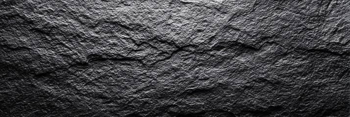 Black stone wall texture. Rough and uneven surface. Natural background.