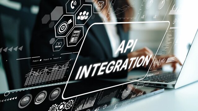 Business professional working on computer with graphic overlay showcasing API integration technology for data connection and management. Asymptotic smart data analytic. - Powered by Adobe