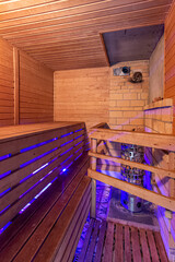 Inside of usual standart wooden sauna room interior with stone and brick with blue backlight