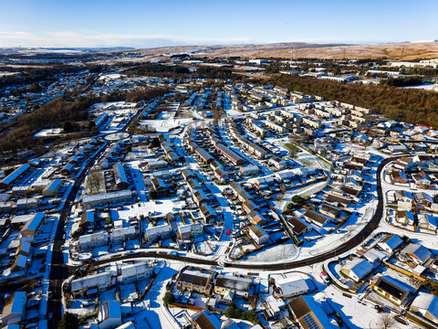 Bright sunny winter day over a snow-covered residential area in the Welsh Valleys