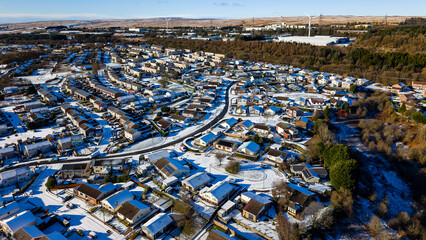 Sunny winter day over a suburban town in the Welsh Valleys with snow on roofs