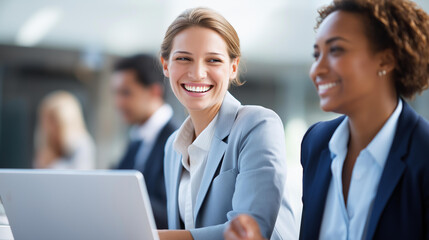 Two beautiful faceless business women working together with laptop talking about job office collaboration professional discussion workplace teamwork