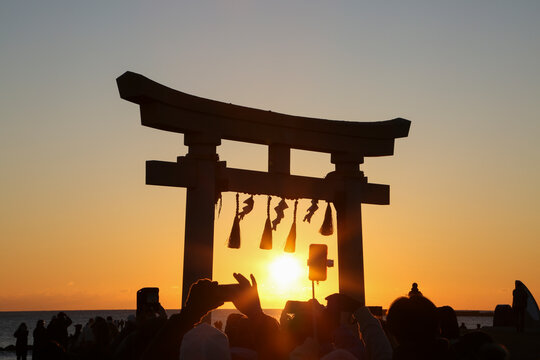鳥居の前で初日の出を迎える日本人
