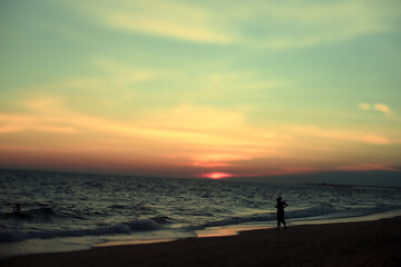 Silhouette of Woman on Beach During Golden Hour Sunset