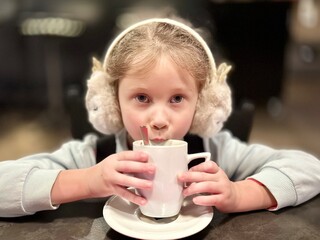 The girl is drinking hot cocoa