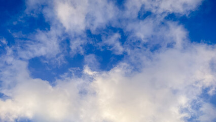 Beautiful blue sky filled with soft white fluffy clouds on a bright clear day, a peaceful view