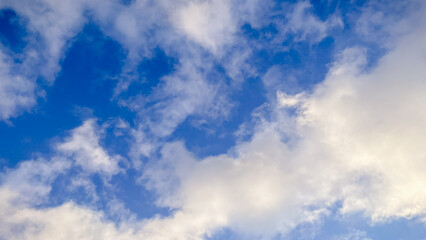 Beautiful blue sky filled with soft white fluffy clouds on a bright clear day, a peaceful view