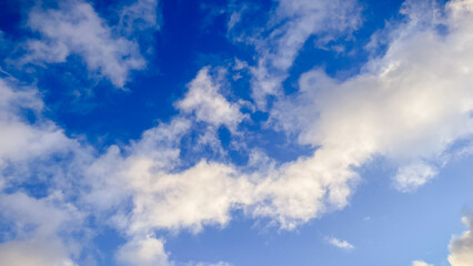 Beautiful blue sky filled with soft white fluffy clouds on a bright clear day, a peaceful view