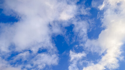 Beautiful blue sky filled with soft white fluffy clouds on a bright clear day, a peaceful view