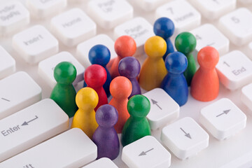 Colorful group of pawn people figures on computer keyboard