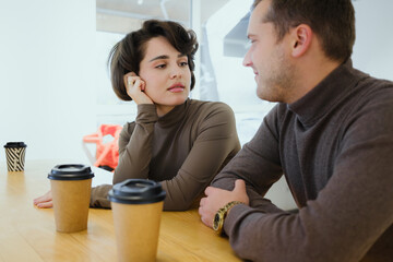 Couple sharing a conversation at a cafe table during a cozy coffee date