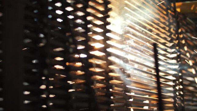 Welding sparks flying through metal grid structure